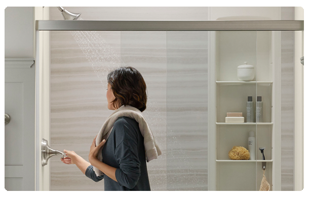 KOHLER LuxStone walls and woman turning on faucet