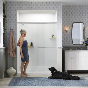 Kohler LuxStone walk-in shower with woman in towel and dog