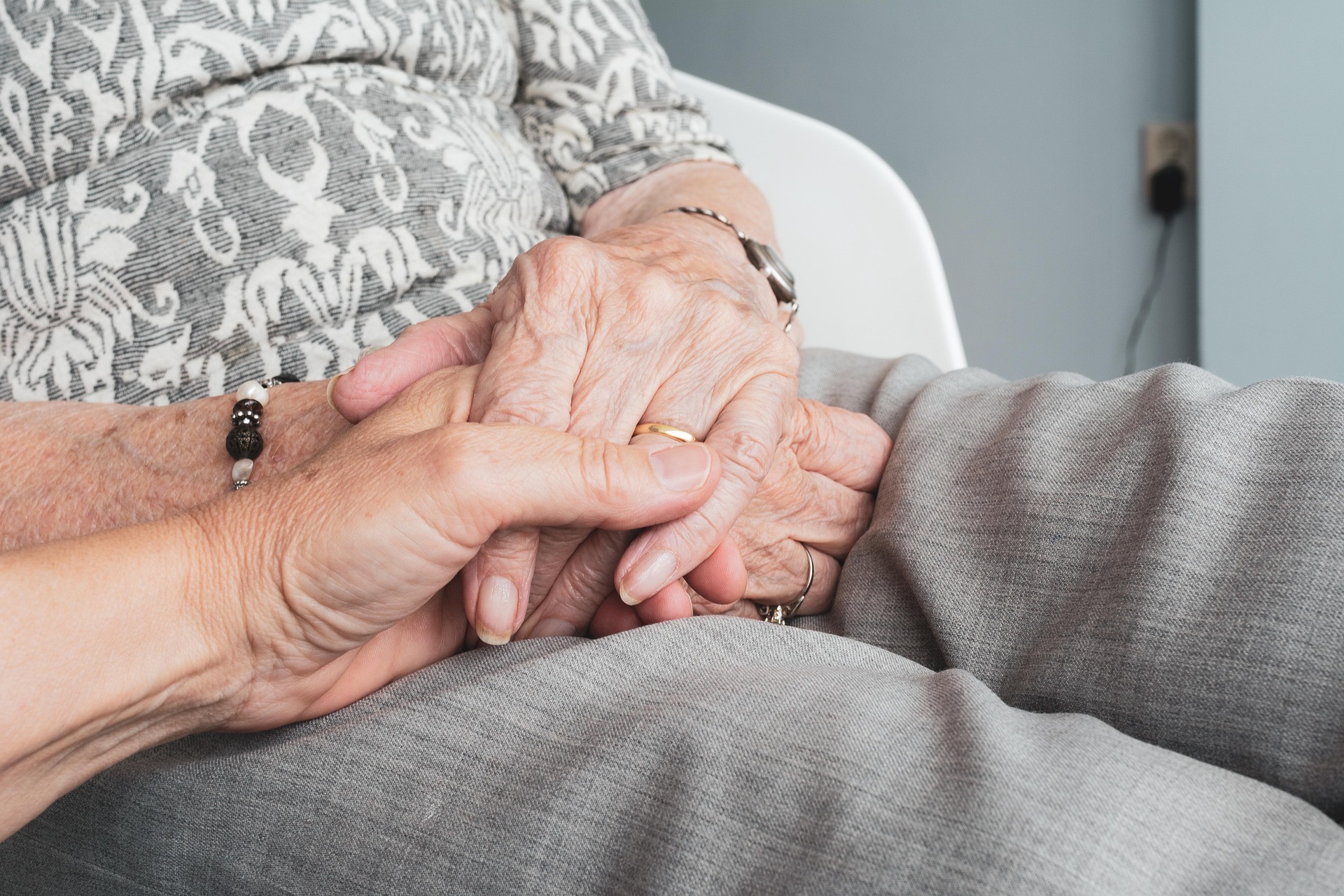 caregiver holding hands with a memory care patient