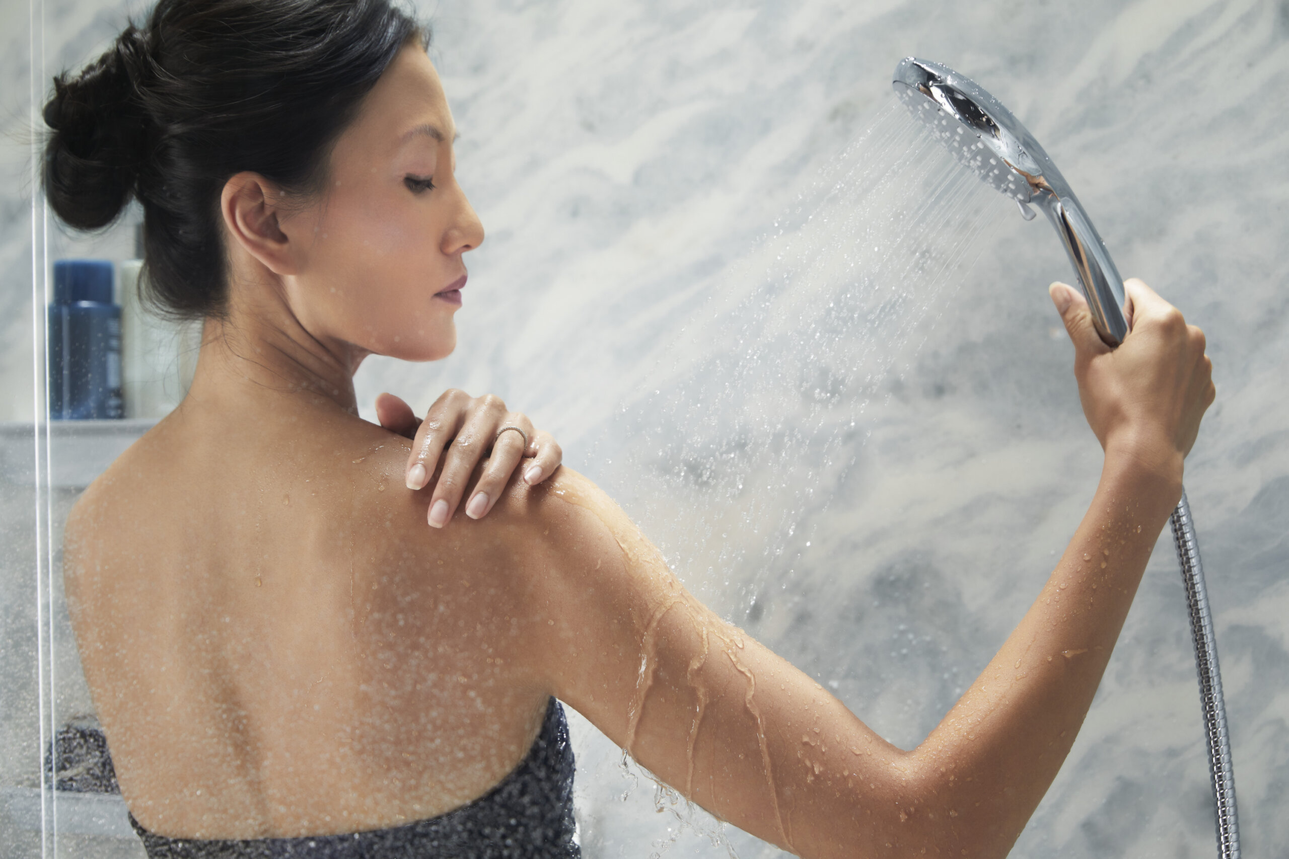 woman showering to relieve muscle aches