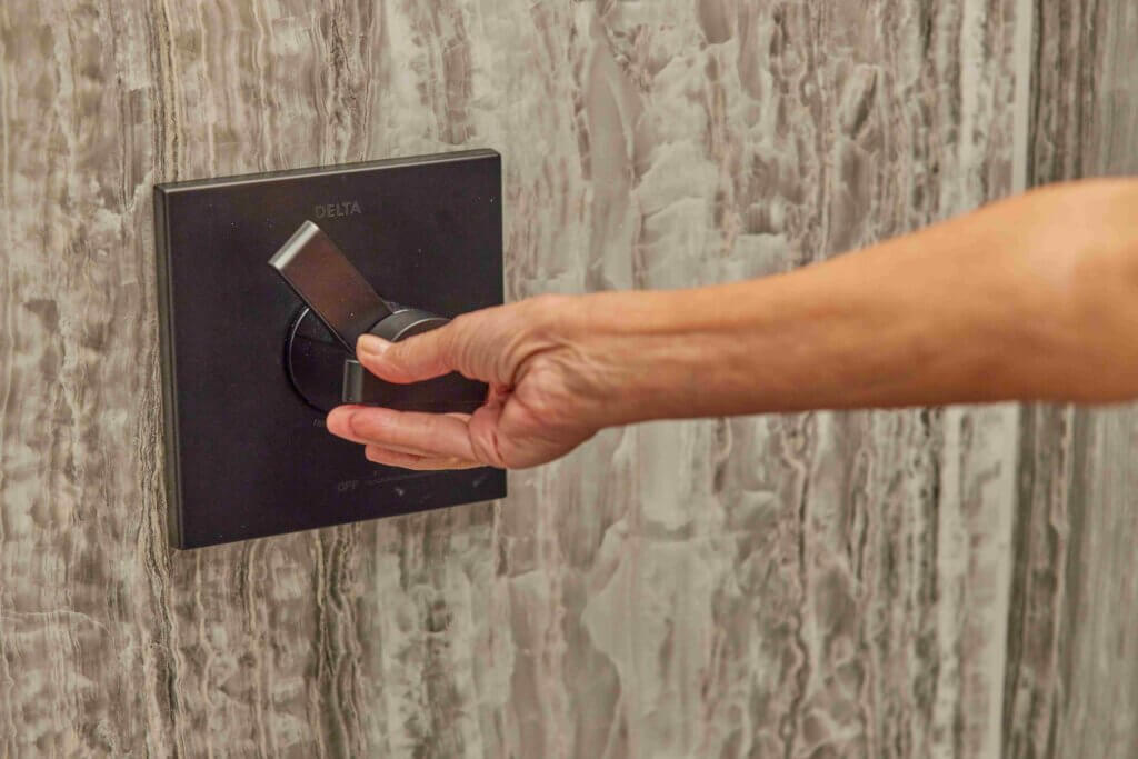 person turning up the temperature of their shower