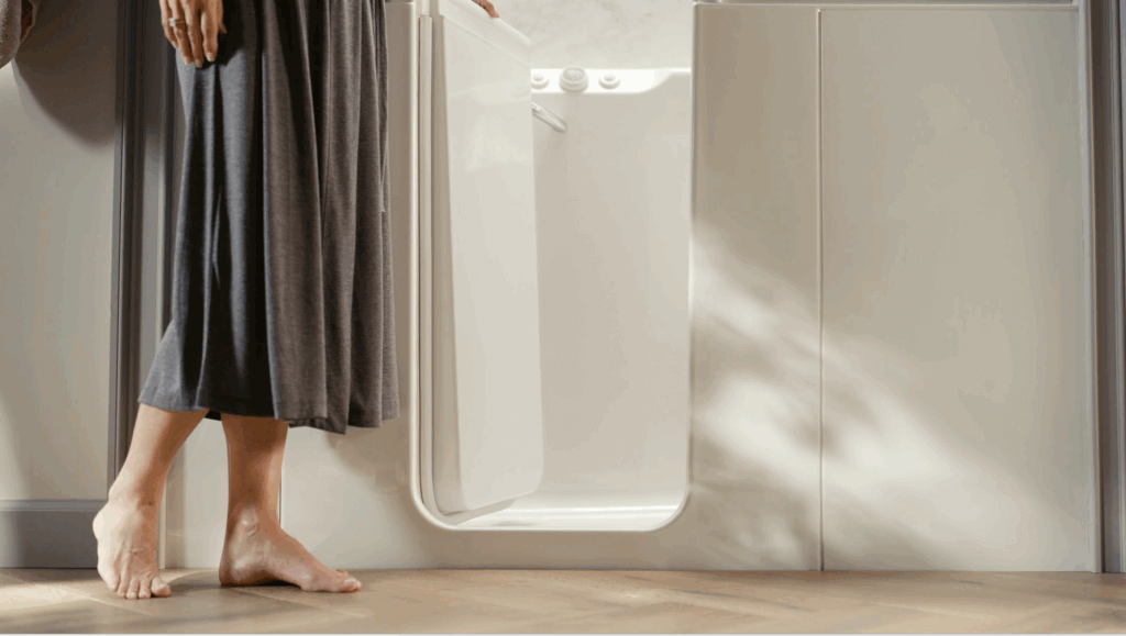woman in a bathrobe entering a KOHLER walk-in bath