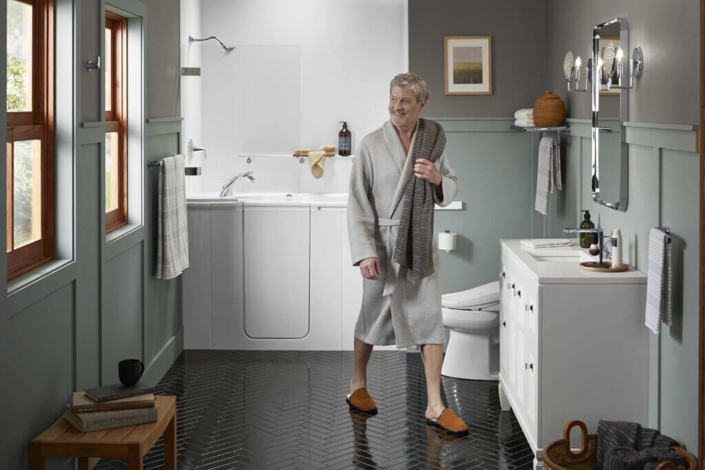 senior man smiling in front of a walk-in bath