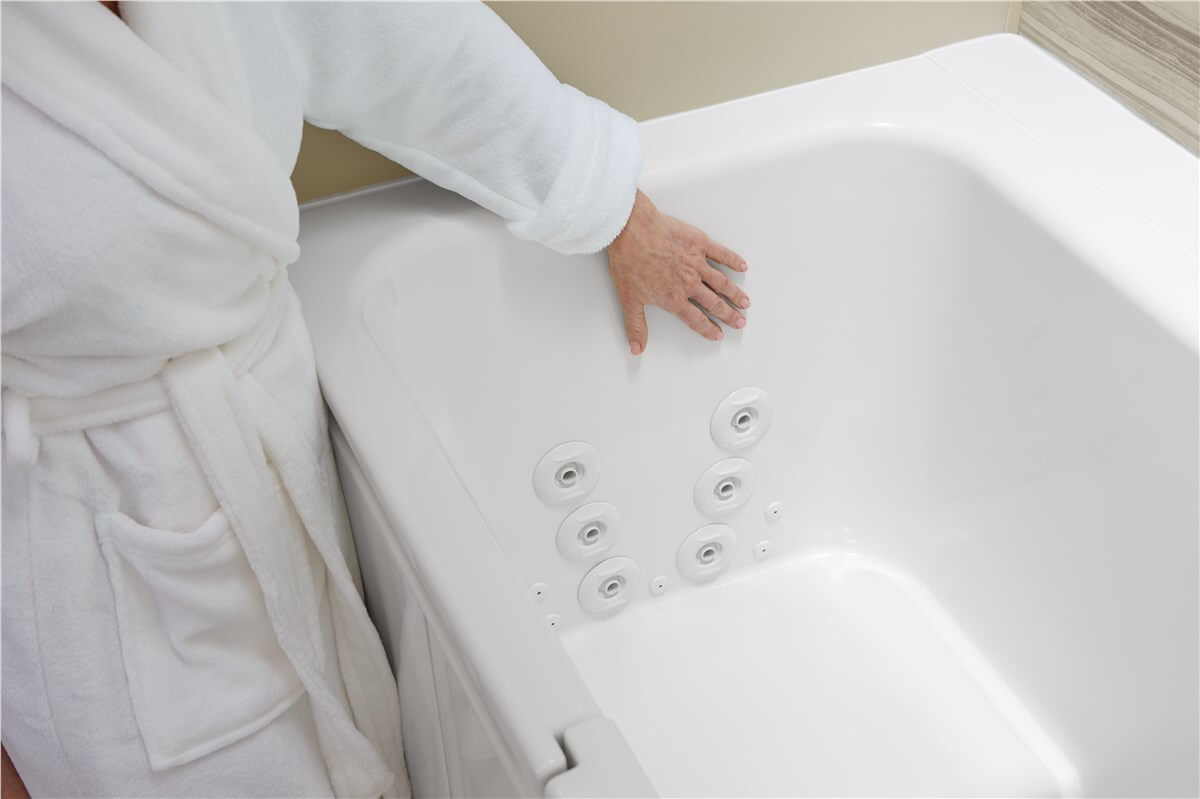 Person touching a KOHLER walk-in bath